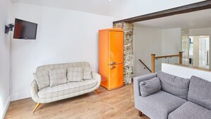 A living room with a beige sofa, a gray sofa, and an orange refrigerator. - Host & Stay | The Duck Pond (Durham)