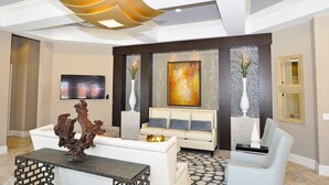 A modern living room with a white sofa, a coffee table, and a TV mounted on the wall. - Amazing 4br Resort Townhome W/ Splash Pool-4686td 4 Bedroom Villa by RedAwning (Davenport)