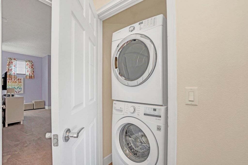 A laundry room with two stacked front-loading washing machines.