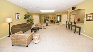 Un salon spacieux comprenant un canapé, des fauteuils, une table basse et un coin repas avec des chaises et une table.