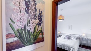 Un dormitorio con una cama, mesitas de noche y una lámpara de pared.