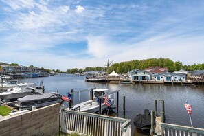 A marina with boats docked, a pier, and buildings with blue doors.