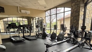 A gym with treadmills, weight machines, and a mirrored wall.