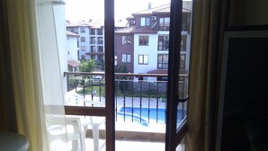 A balcony with a view of a swimming pool and residential buildings. - Stunning Apartment With Pool in Ravda, Bulgaria (Nessebar)