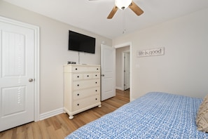 A bedroom with a bed, dresser, television, and a motivational sign. - GaGa's Getaway: Quiet location, dog-Friendly, fire pit, 3-night min. (Kill Devil Hills)