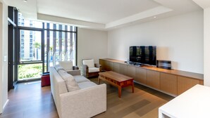 Un soggiorno moderno con un divano, un tavolino da caffè e una TV su un mobile in legno.