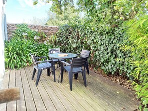 Relax in a serene outdoor space surrounded by lush greenery and a stone wall.