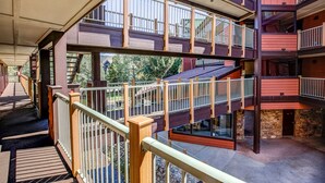 A multi-level building with balconies, wooden railings, and a stone facade.