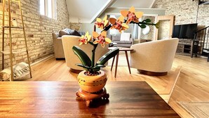Un loft moderne avec des murs en briques apparentes, une table à manger en bois et une grande fenêtre.
