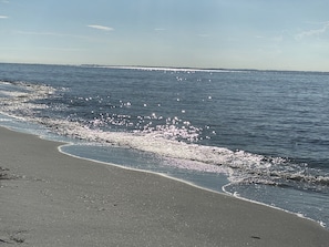 Une plage avec un ciel dégagé et une mer calme.