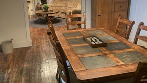 A dining area with a wooden table, chairs, and a chandelier. - Step Back in Time Near The Missouri River (Jamestown)