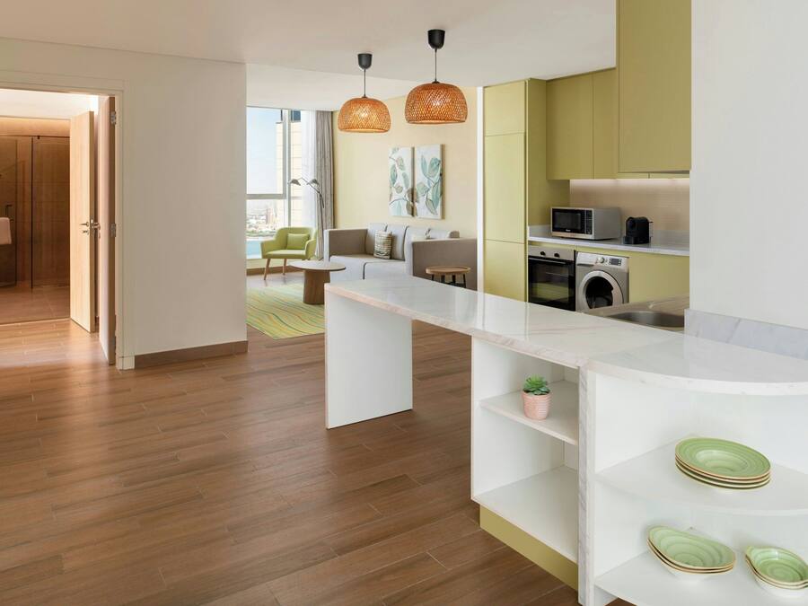 Una cocina moderna con una isla central, electrodomésticos integrados y vistas al área de estar.