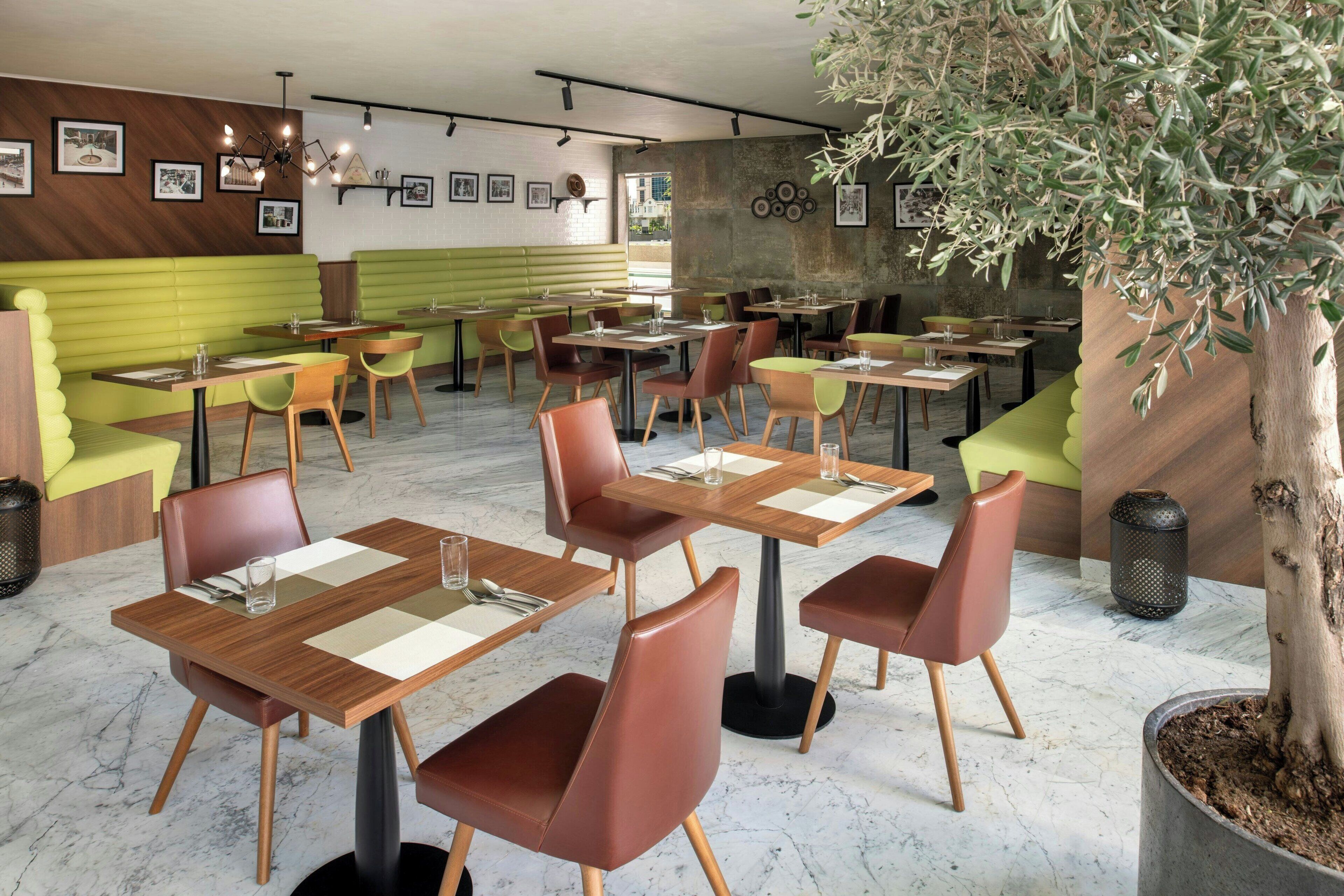 Interior de restaurante com cabines, mesas e cadeiras.