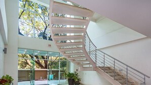A spacious interior with a spiral staircase, large windows, and potted plants. - PP201: Modern Space in Centre of Town (Tamarindo)