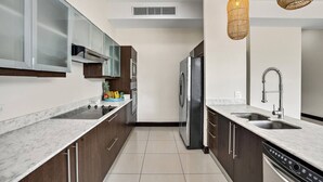 A modern kitchen with a stainless steel refrigerator, double sink, and wooden cabinets. - PP201: Modern Space in Centre of Town (Tamarindo)