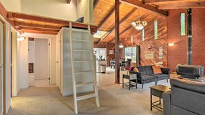 A spacious loft with exposed wooden beams, a loft bed, a fireplace, and a cozy seating area. - Step-Free Hawkins Bar Home Near Trinity River (Salyer)