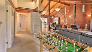 A cozy room with a foosball table, a sofa, and a loft bed. - Step-Free Hawkins Bar Home Near Trinity River (Salyer)