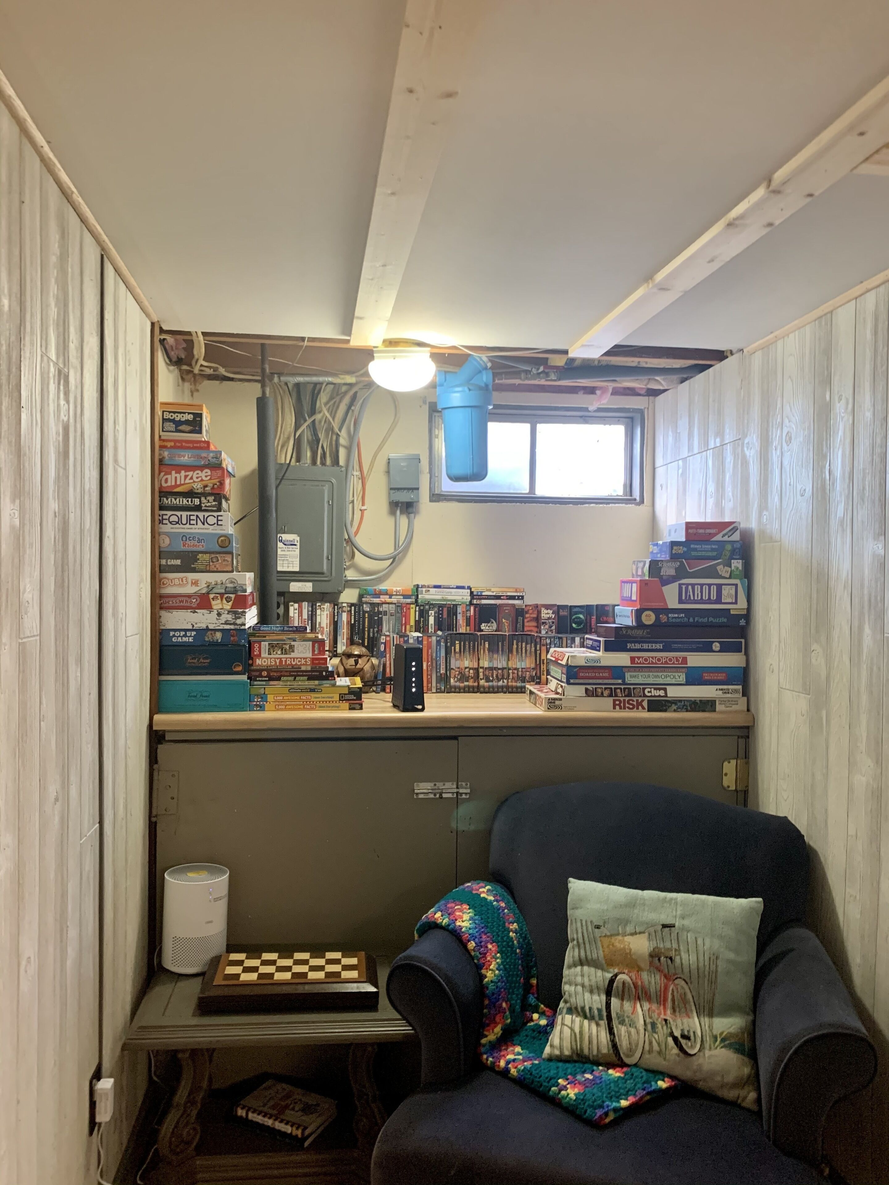 Una habitación con techo de madera, una ventana y un escritorio con computadora y un tablero de ajedrez.