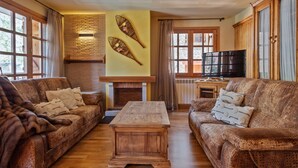 A cozy living room with two sofas, a coffee table, a fireplace, and a TV. - Luderna - Apartamento D2 Suriguera de Canillo (Canillo)