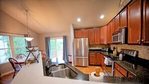 Una cocina moderna con gabinetes de madera, electrodomésticos de acero inoxidable y una isla grande con un lavaplatos.