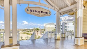 Een overdekt buitengebied met een bord waarop staat: Beach Club at Pointe West.