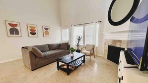 A living room with a sofa, coffee table, and a fireplace. - Spacious | Large Groups | Katy Mall, Parks! (Katy)