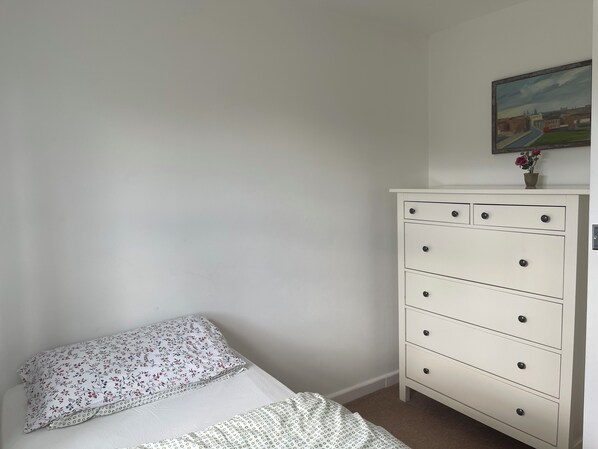 A bedroom with a bed, a dresser, and a painting on the wall. - Private 3-Cottage Countryside Retreat for Groups | Pool, Hot Tub & Sleeps 19 (Stewton)
