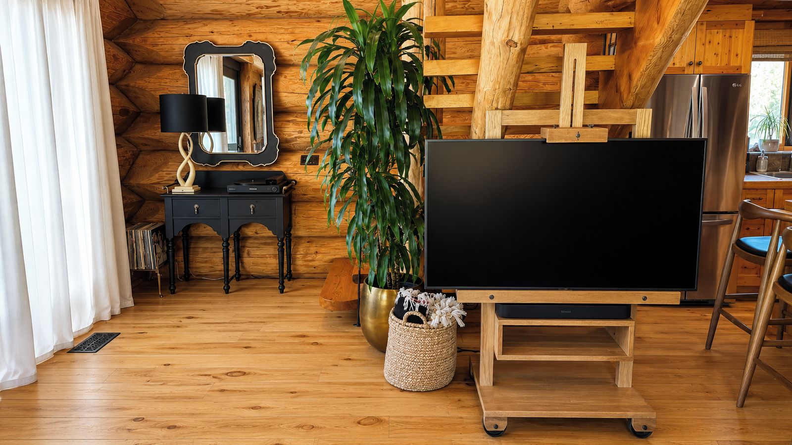 Quarto acolhedor com decoração em madeira, TV de tela plana em um suporte, uma planta e um espelho na parede.