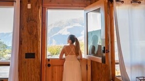 Ein Holzinnenraum mit einem großen Fenster, einer Tür und einem Spiegel.