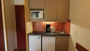Eine kompakte Küche mit einer Mikrowelle, einer Kaffeemaschine und zwei Geschirrspülern.