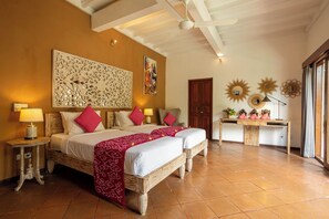 A hotel room with a large bed, two bedside tables, a desk, and a decorative wall panel.