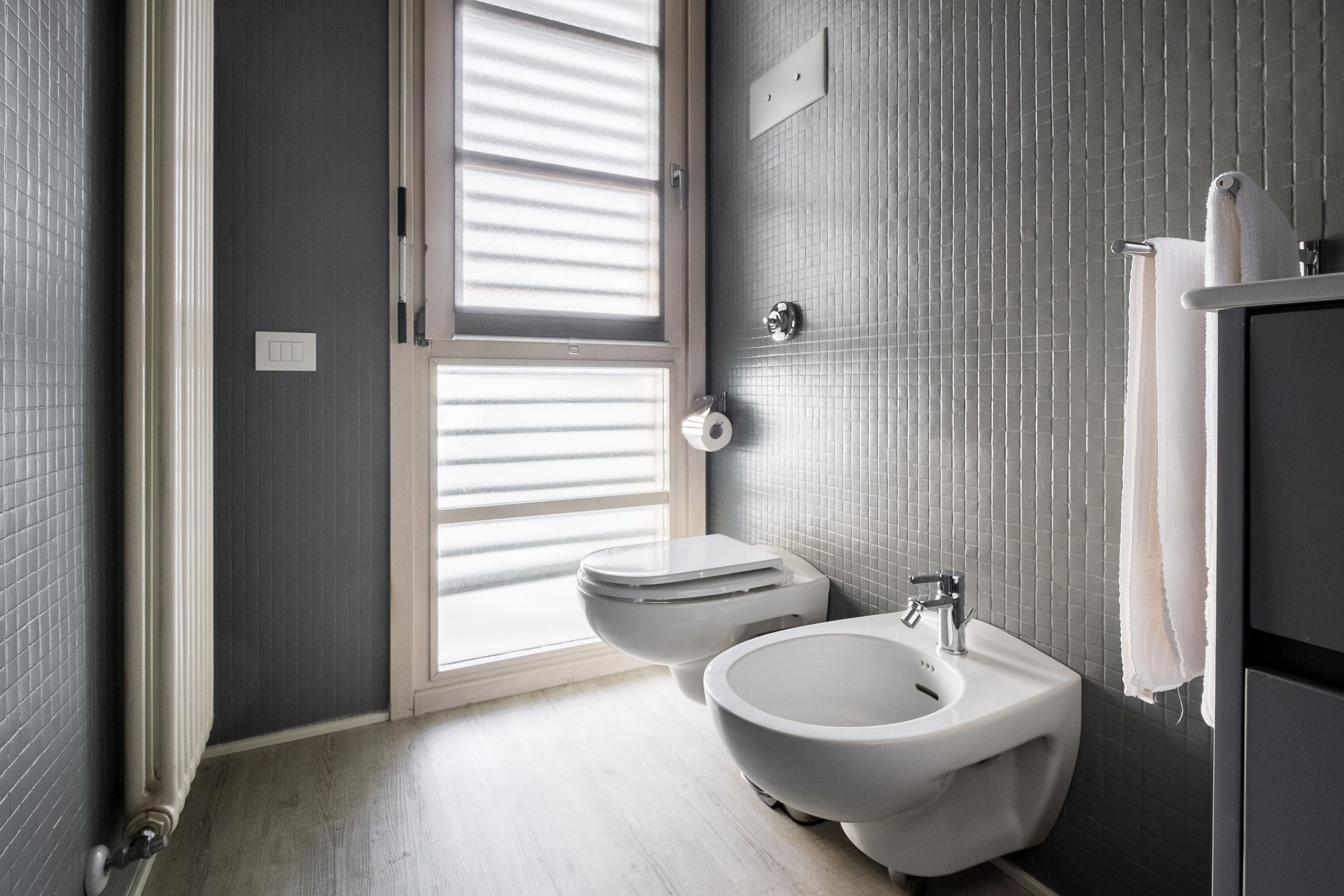 Un baño moderno con bidé, inodoro y lavamanos.