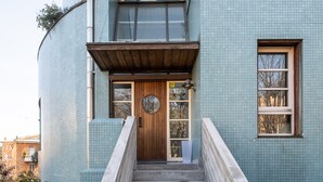 Una escalera que conduce a un edificio con una puerta de madera y ventanas.