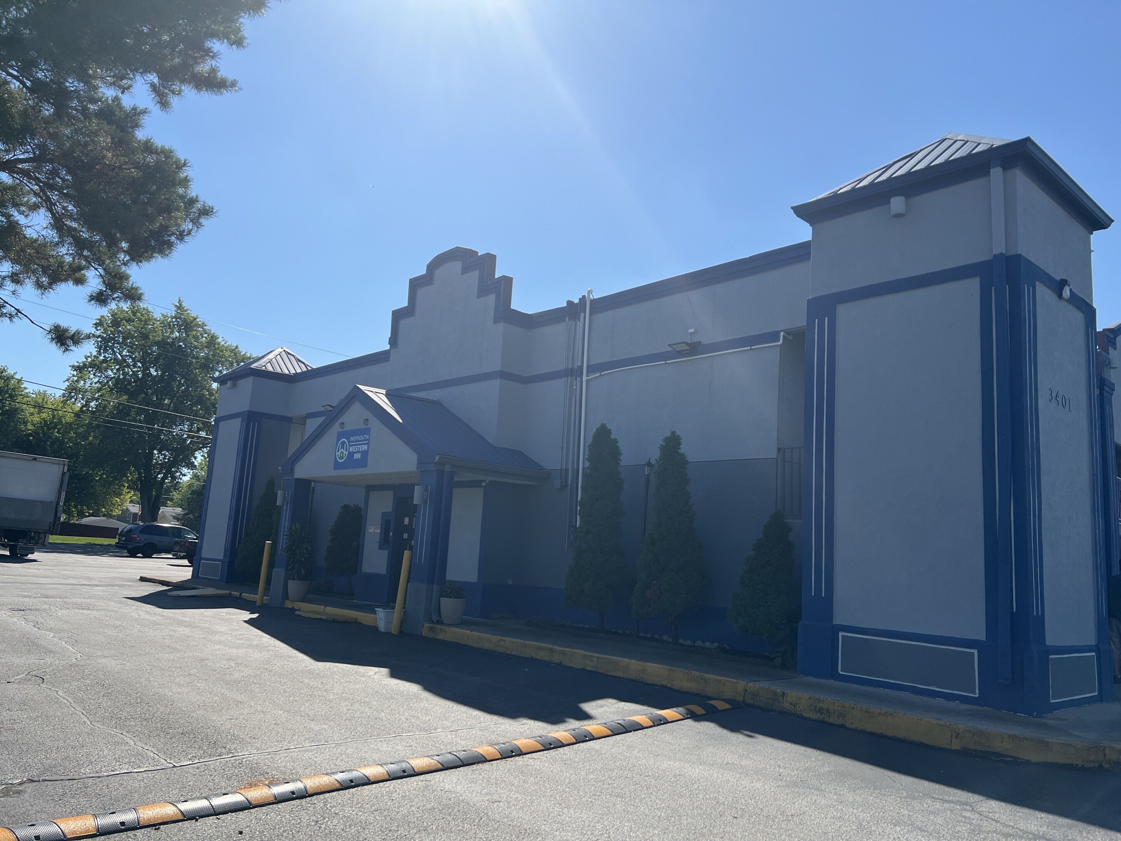 A Western Inn building with a blue and white exterior, a covered entrance, and a parking lot. - Indysouth western inn (Indianapolis)