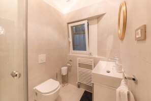 A modern bathroom with a toilet, sink, and shower. - AB Ljubljana - The Residence (Ljubljana)