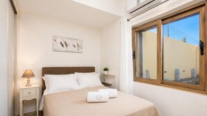 A neatly arranged bedroom with a bed, bedside lamp, and a window with a view.