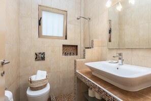 Ein modernes Badezimmer mit einem großen Waschbecken, einer Dusche und einer Toilette.