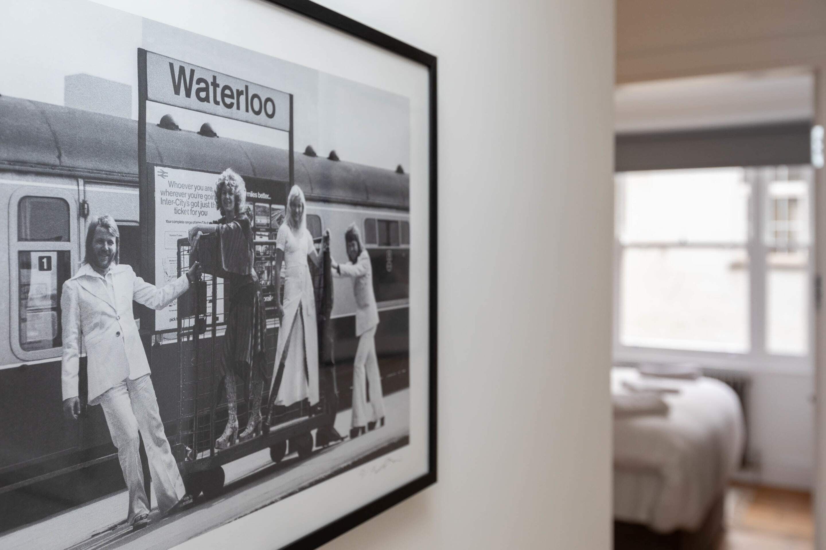 Una foto en blanco y negro enmarco, de un tren con la palabra 'Waterloo', exhibida en una pared.