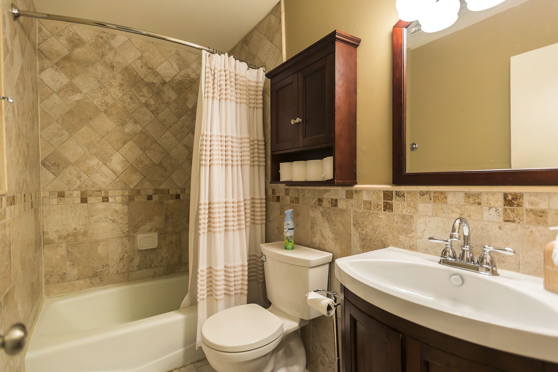 A bathroom with a bathtub, toilet, and sink.