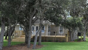 A residential property with a wooden deck, a fenced yard, and mature trees. - Waterfront house with beautiful views of Perdido Bay facing Florida. (Elberta)