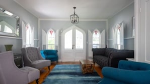 A living room with a wooden floor, a blue rug, and two sofas.