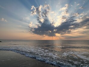Una playa con olas y un cielo nublado.