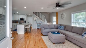 A modern living space with a kitchen, dining area, and a staircase leading to an upper level. - Private Heated Pool - 1 Block from the Beach! (Tybee Island)