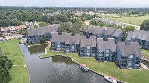 A residential complex with multiple buildings, a canal, and boats.