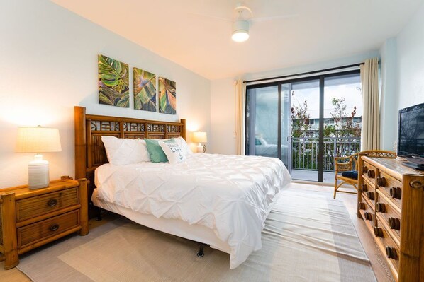 A bedroom with a large bed, two bedside tables, a TV, and a balcony with a view. - ATLANTIC HIDEAWAY- Key West (Key West)