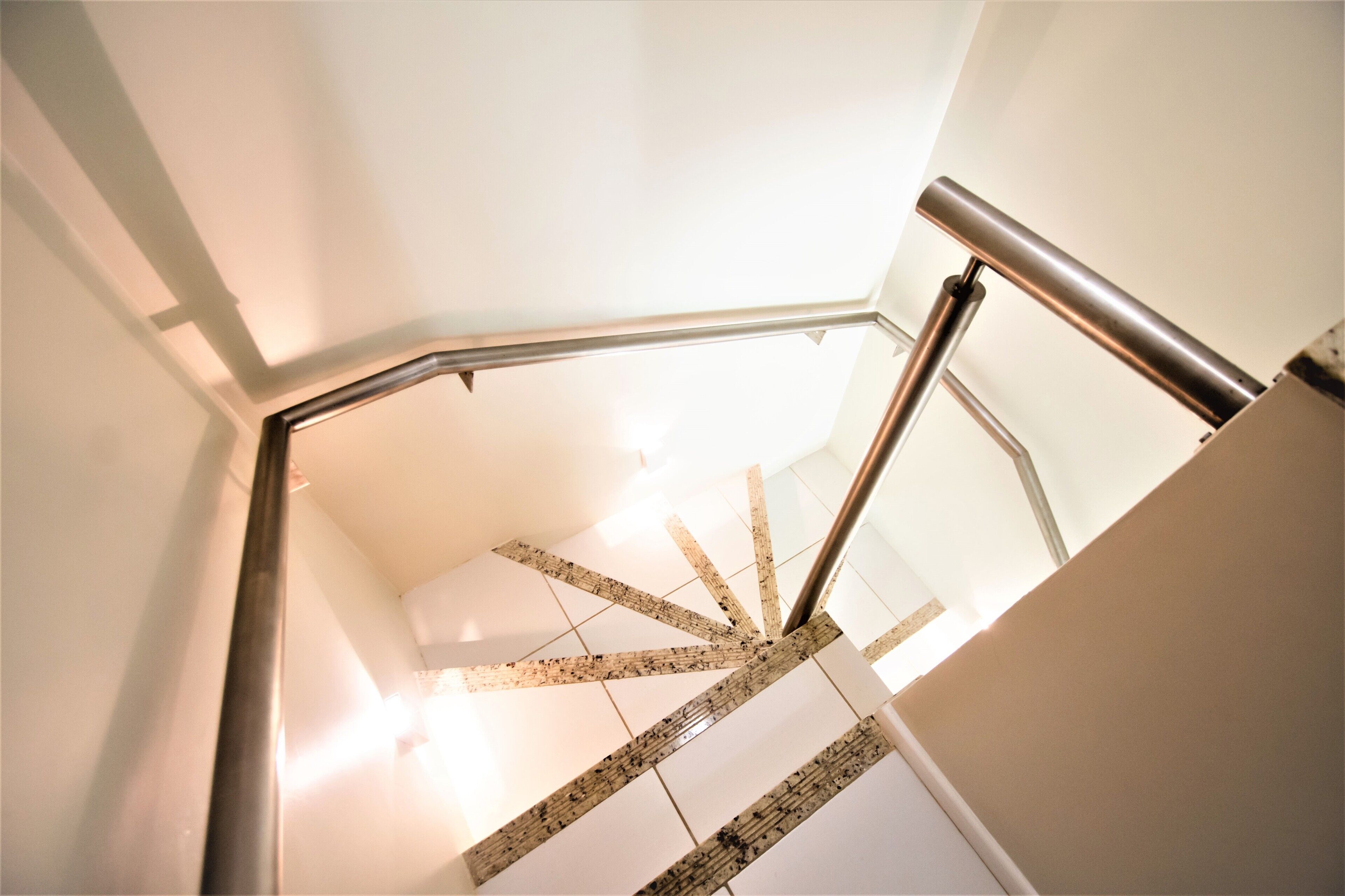 Una escalera con barandilla metálica y escalones de madera.