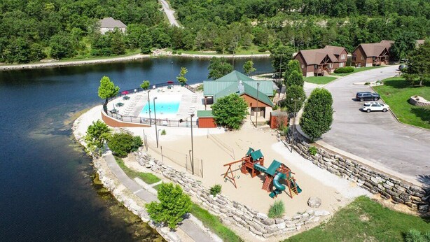 Une propriété située au bord d’un lac, dotée d’une piscine, d’un espace de jeux pour enfants et d’un parking.