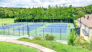 A tennis court with multiple courts, surrounded by a fence, and a building with a stone facade in the background. - Perfect Cabin Retreat! Close to Silver Dollar City (Branson West)