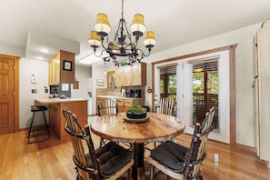 A dining area with a wooden table, chairs, and a chandelier.