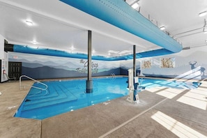 An indoor swimming pool with a mural of mountains and a blue sky on the wall. - ONE MILE to Silver Dollar City! Rustic Cabin! (Branson)